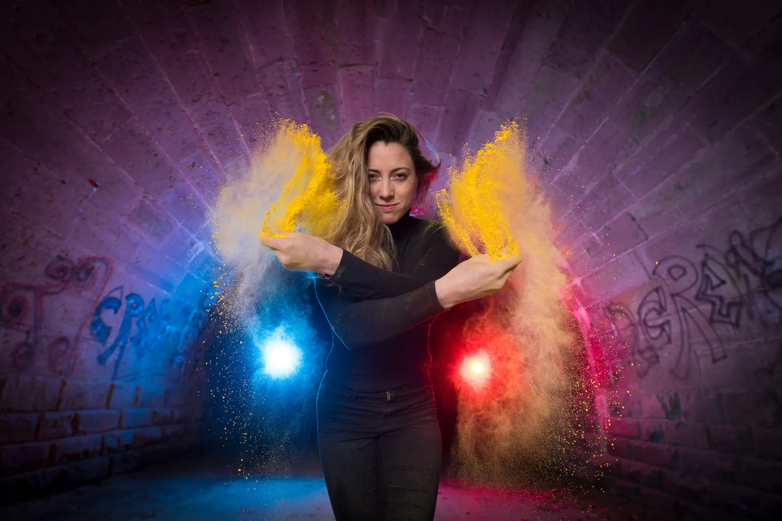 Kreativ inszeniert Frau mit Farbpulver in einem Tunnel, freies Werbefoto mit Nina Treiber zu Dynamik, Farbe und Kontrast